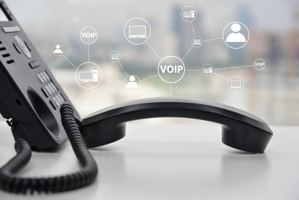 Close-up of a VoIP desk phone with digital icons representing cloud communication and business connectivity
