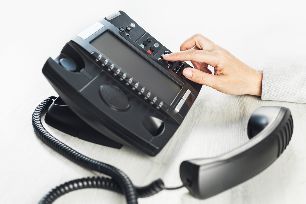 Modern Yealink VoIP desk phone on office workstation